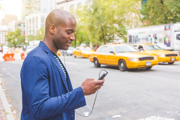 Jonge zwarte man in New York kijkt naar zijn telefoon