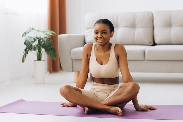 Jonge zwarte vrouw die thuis mediteert, yoga online concept, vrije ruimte