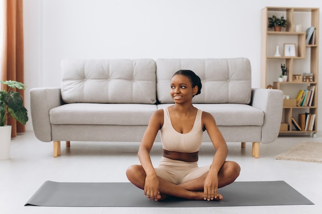 Jonge zwarte vrouw mediteren thuis yoga online concept vrije ruimte