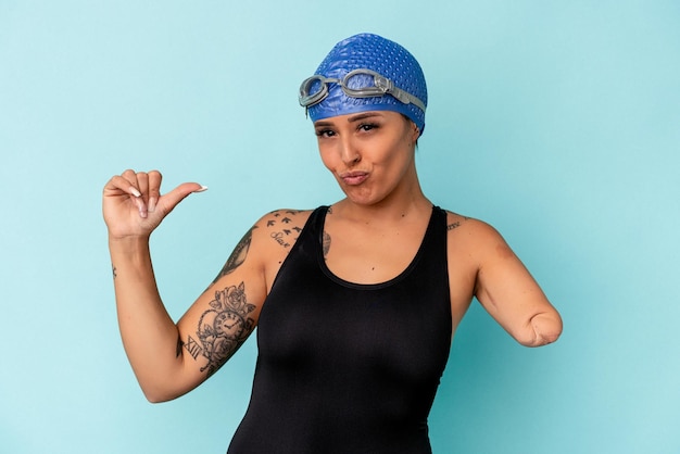 Jonge zwemmer blanke vrouw met één arm geïsoleerd op blauwe achtergrond voelt zich trots en zelfverzekerd, voorbeeld om te volgen.