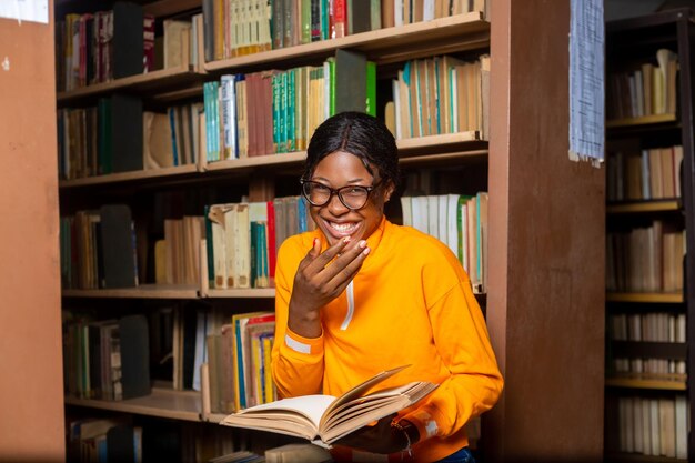 Jongedame campusstudent in de bibliotheek aan het lezen