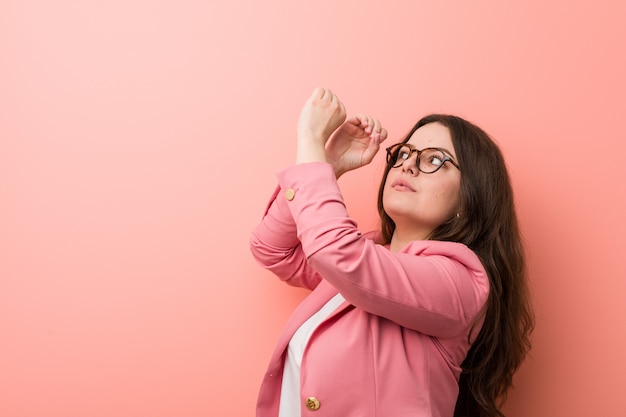 Jongelui plus grootte bedrijfs kaukasische vrouw die ver weg kijkend hem hand op voorhoofd kijken.