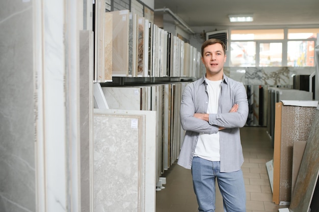 Jongeman die tegels kiest op de bouwmarkt