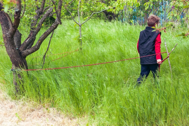 jongen bindt bomen vast met touw