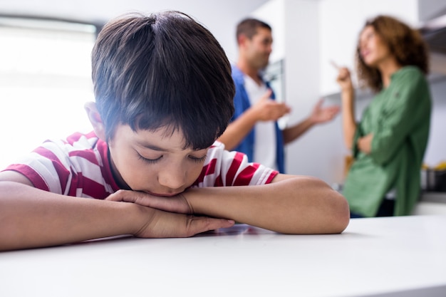 Jongen die droevig voelt terwijl zijn ouders ruzie maken