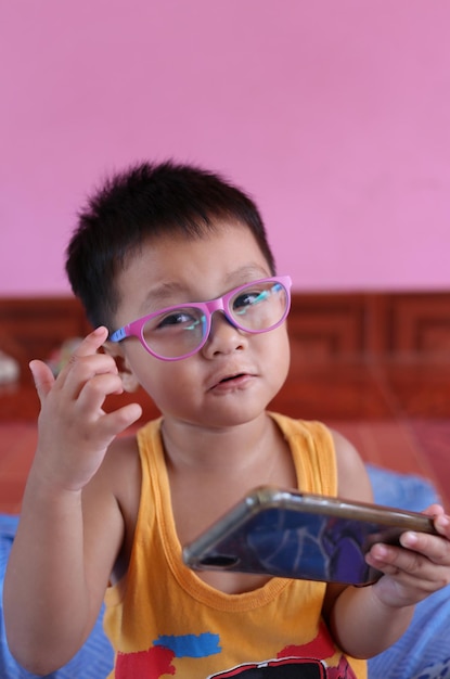 Foto jongen die een bril draagt en smartphone speelt