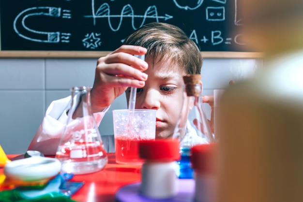 Jongen die een jas draagt terwijl hij in de klas zit