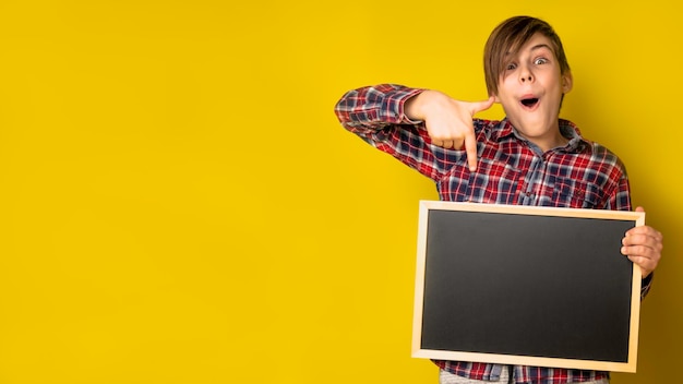 Foto jongen die een leeg krijtbord houdt