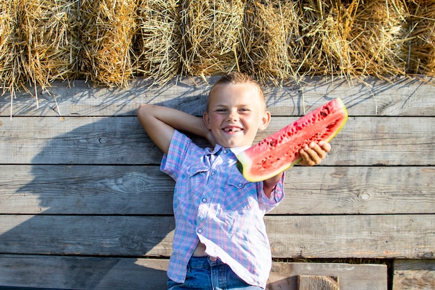 Jongen die een plak van watermeloen houdt