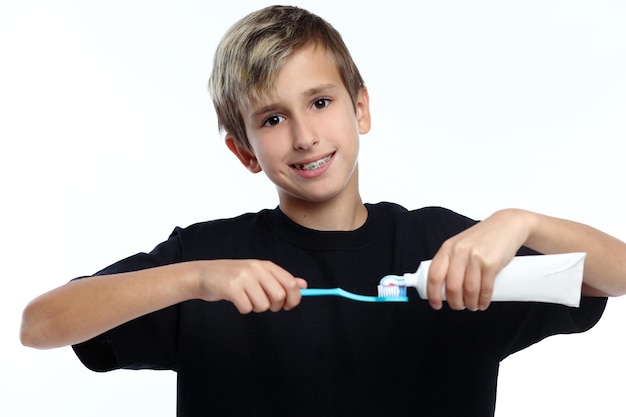 Jongen die een tandenborstel vasthoudt en zich voorbereidt om zijn tanden te poetsen terwijl hij naar jou kijkt