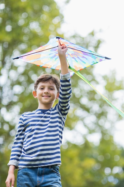 Jongen die een vlieger in park houdt