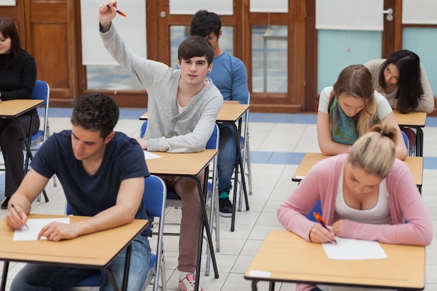 Jongen die hand opheft tijdens examen