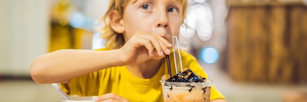 Jongen die ijs eet in een lang formaat van een cafébanner