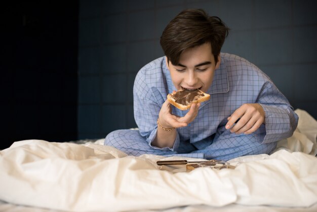 Foto jongen die knapperige toost in bed eet