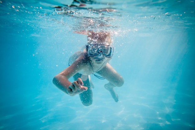 Jongen die onder water in pool zwemt