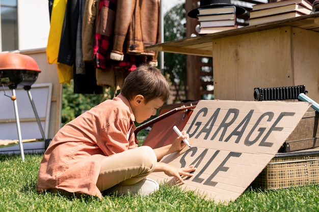 Jongen die op kartonbanner schrijft