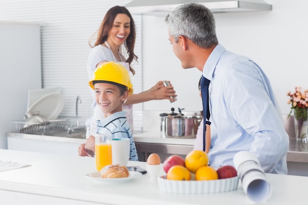 Jongen die op vadersbouwvakker met ouders het lachen probeert