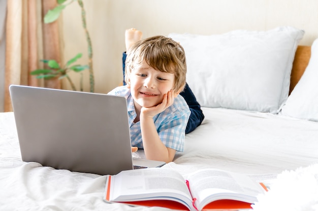 Jongen die thuis met laptop bestudeert