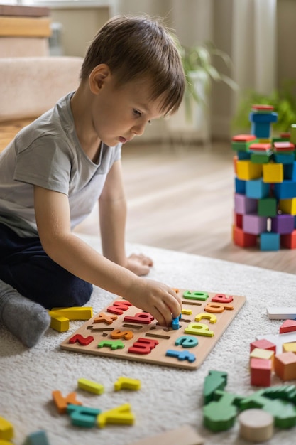 Jongen die thuis met speelgoedblokken speelt