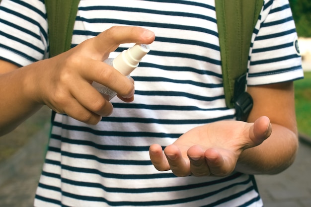 Foto jongen die zijn handen met handdesinfecterend middel desinfecteert