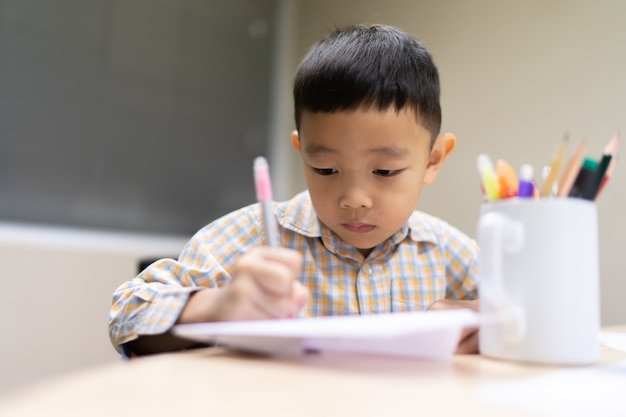 Jongen doe en concentreer je op zijn huiswerk