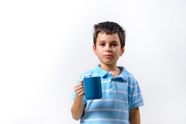 Jongen drinkt uit een blauwe beker geïsoleerd