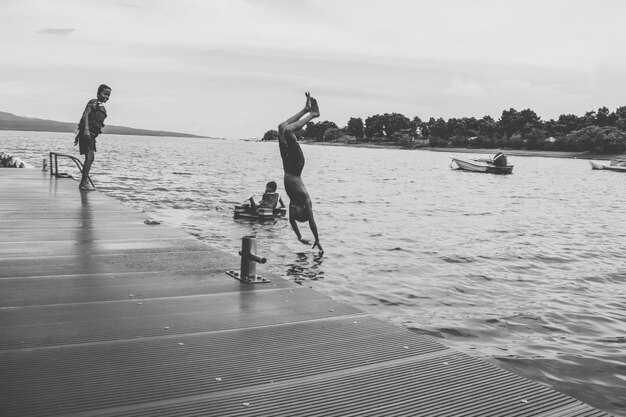 Foto jongen duikt in de zee op het strand