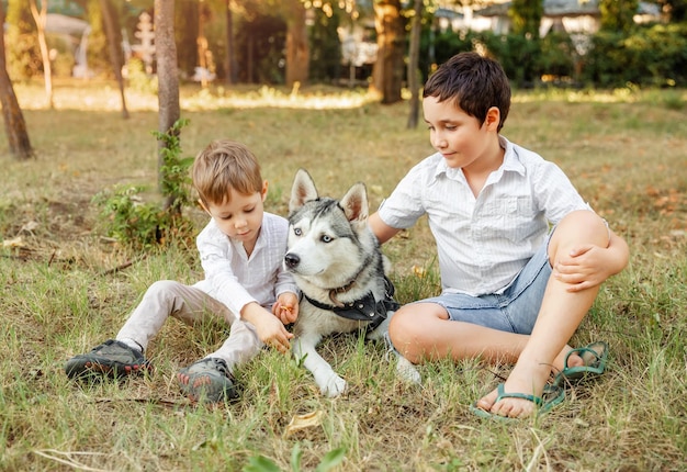 Jongen en hond zitten op het veld.