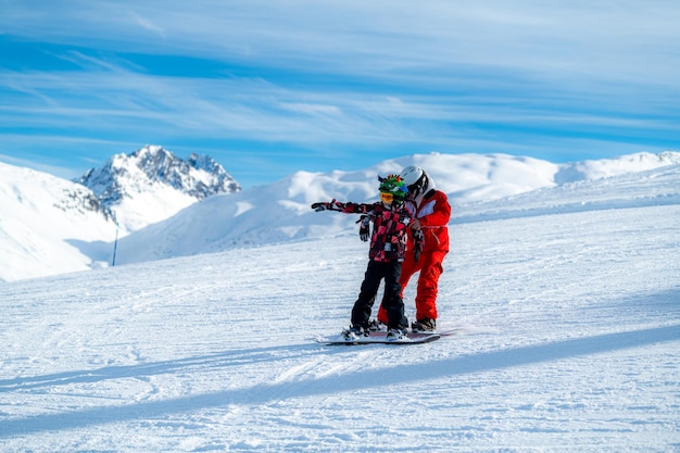 Jongen en instructeur op snowboardles.