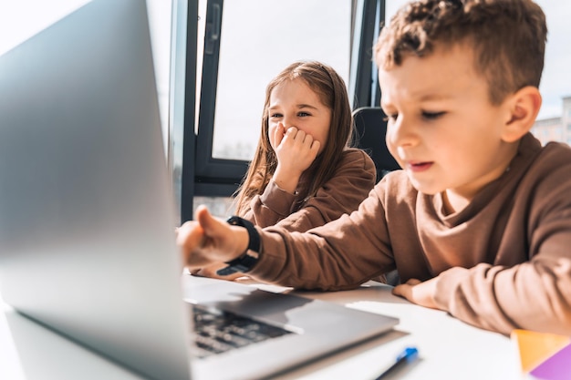 Jongen en meisje achter laptop