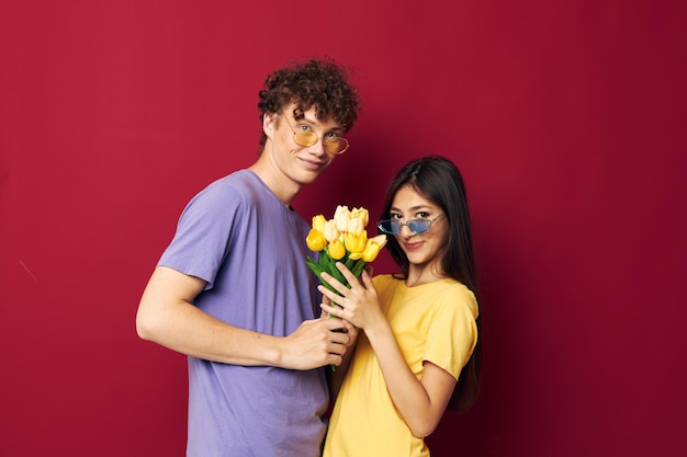 Jongen en meisje cadeau boeket bloemen leuke rode achtergrond ongewijzigd