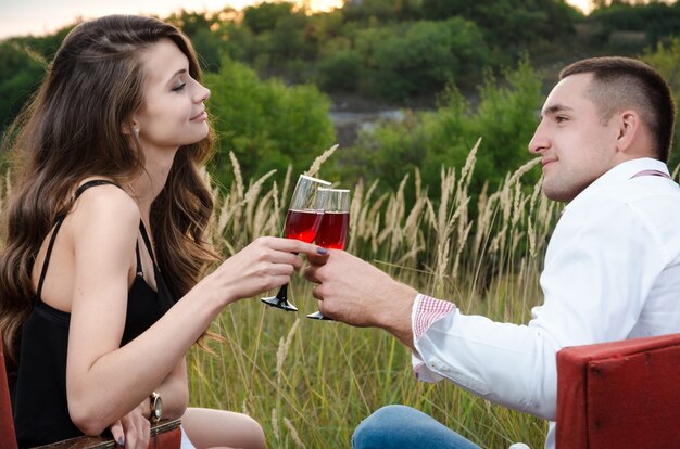 Jongen en meisje die buiten wijn drinken