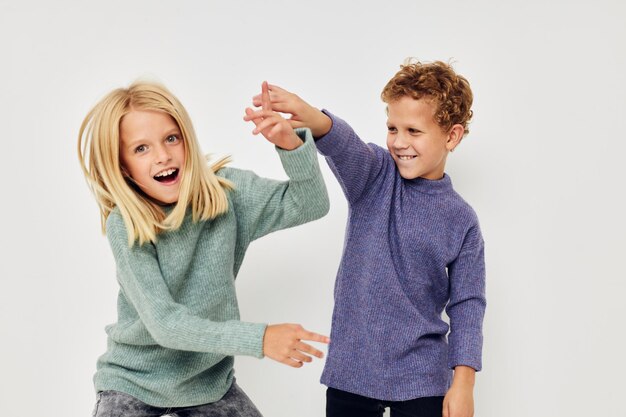 Jongen en meisje kinderen poseren op een witte achtergrond en glimlachen