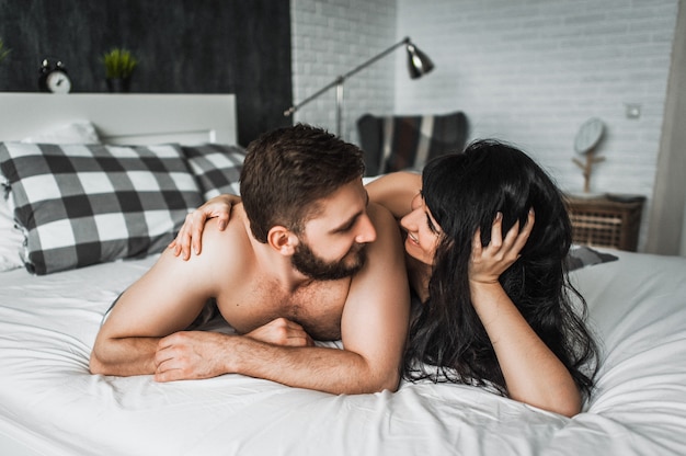 Jongen en meisje knuffelen in bed. jongen en meisje hebben seks. verliefde paar in bed. huwelijksnacht. de liefde bedrijven. liefhebbers in bed