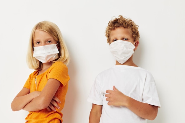 Jongen en meisje leuk medisch masker staan naast elkaar close-up lichte achtergrond