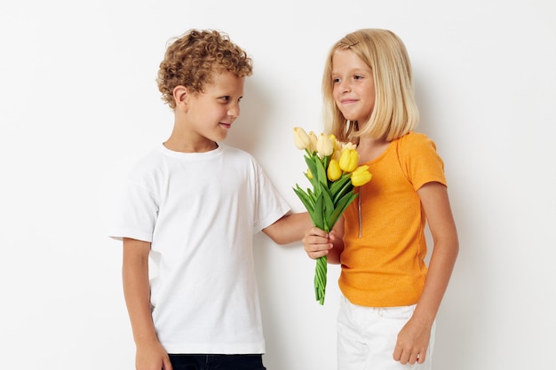 Jongen en meisje leuk verjaardagscadeau verrassing boeket bloemen geïsoleerde achtergrond ongewijzigd