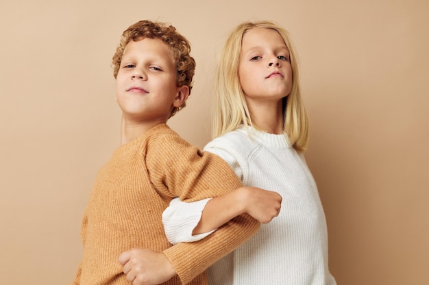 Jongen en meisje staan naast het poseren van emoties beige achtergrond