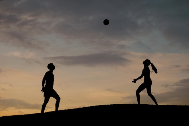 Jongen en meisje volleyballen op de natuur.