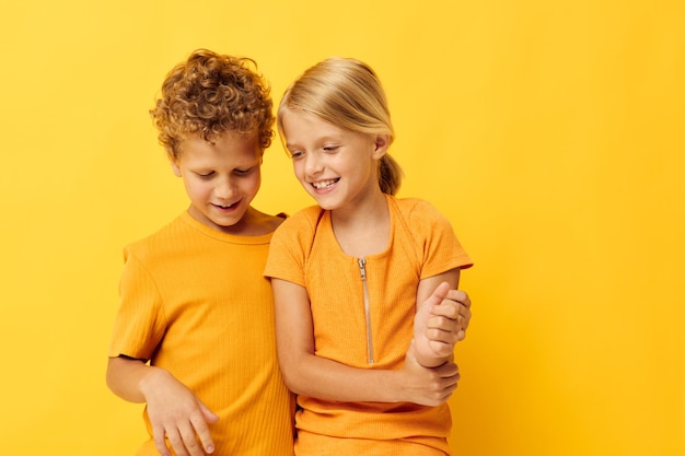 Jongen en meisje vrijetijdskleding spelletjes leuk samen poseren op gekleurde achtergrond