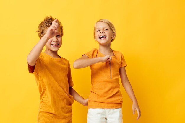 Jongen en meisje vrijetijdskleding spelletjes leuk samen poseren op gekleurde achtergrond