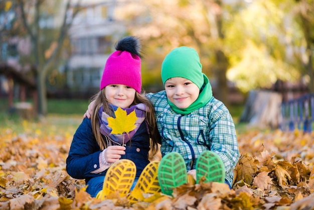 Jongen en meisje zitten tijdens wandeling in herfst regenachtig park