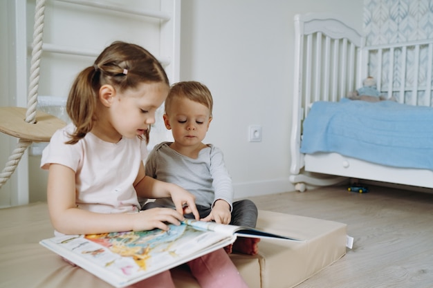 jongen en meisjes die een boek lezen in de kinderkamer