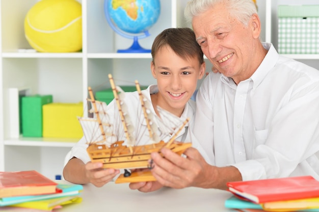 Jongen en opa met model schip thuis