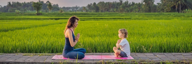 Jongen en zijn yogaleraar die yoga doen in een lang formaat van een rijstveldbanner