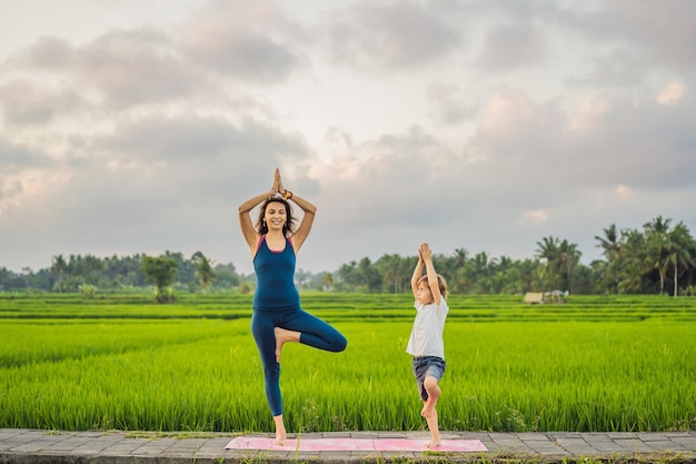 Jongen en zijn yogaleraar doen yoga in een rijstveld