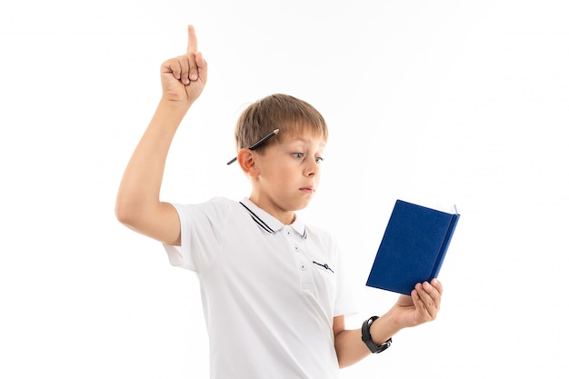 jongen hief zijn vinger omhoog tijdens het lezen van een boek over wit