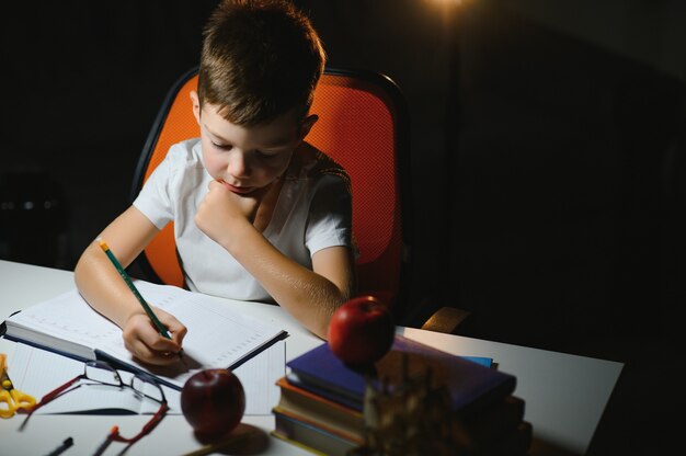 Jongen huiswerk thuis in de avond