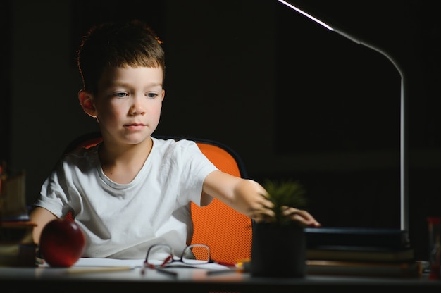 Jongen huiswerk thuis in de avond