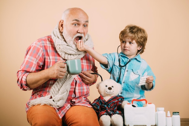 Jongen in doktersuniform behandel patiënt Gezondheidszorgberoep mensen en geneeskundeconcept Grootvader an