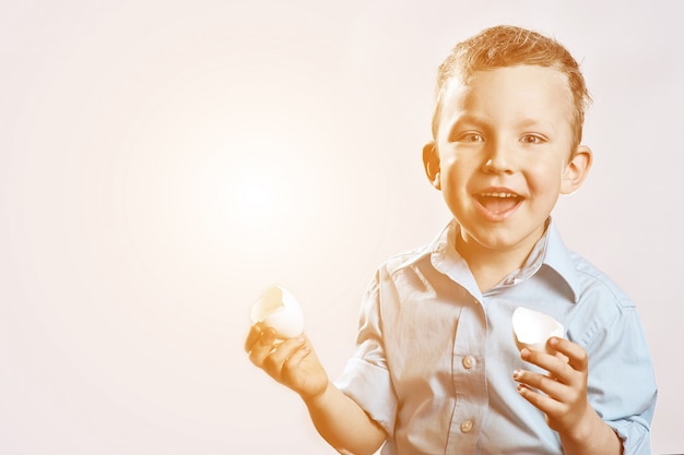 Jongen in een licht shirt met een schaal van het ei en glimlachen